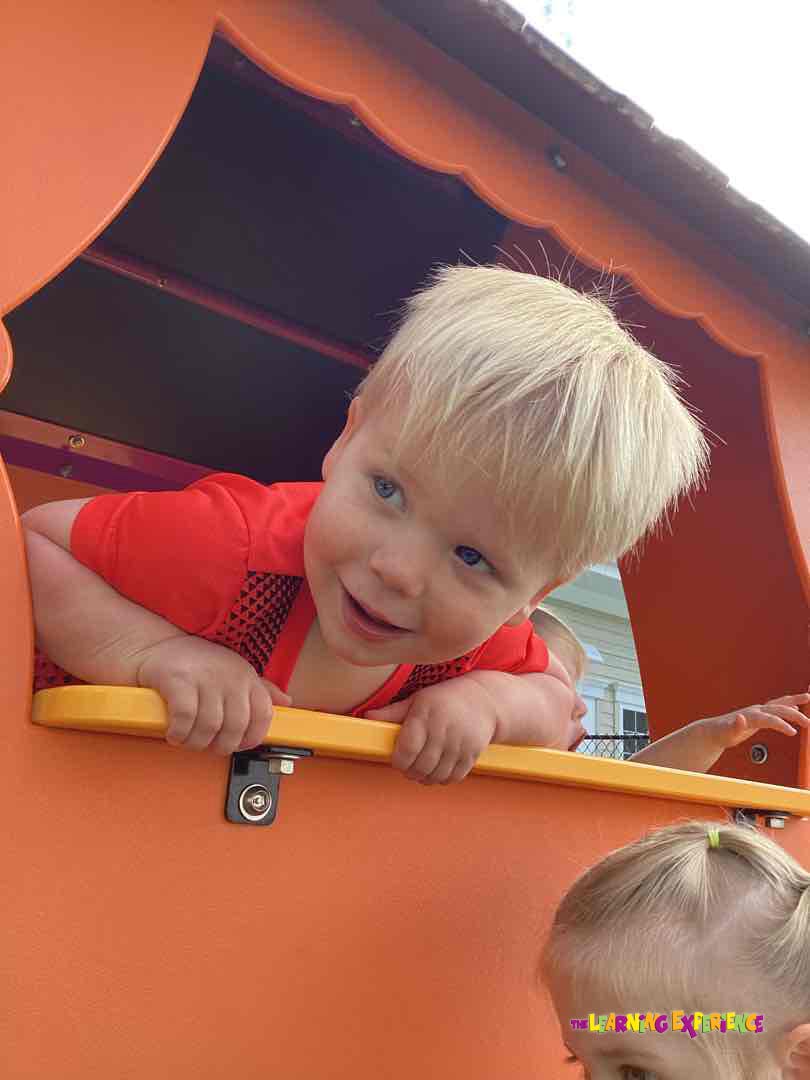 Child looking out of a window in a playhouse