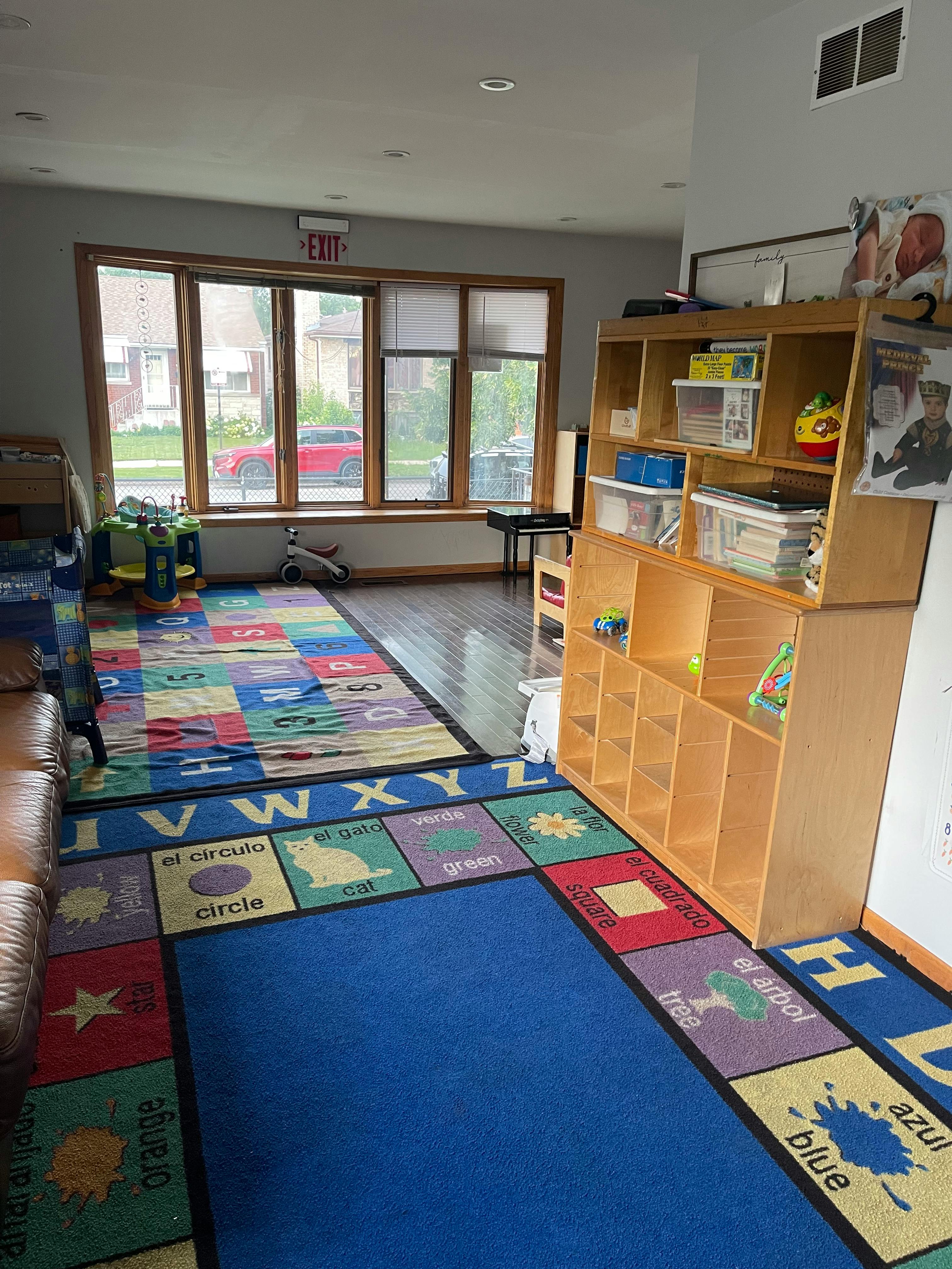 Classroom with alphabet rugs, wooden shelving, and large windows
