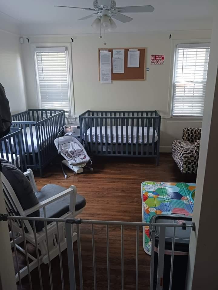 Room with two cribs, a baby bouncer, and a rocking chair