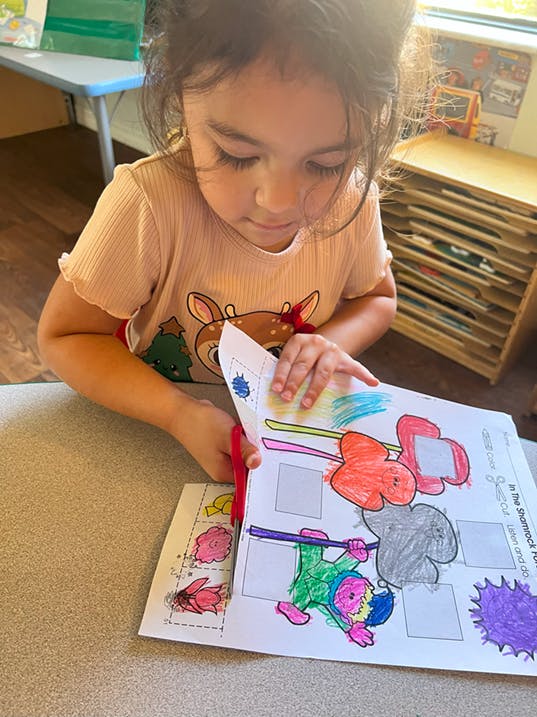Child cutting paper with scissors