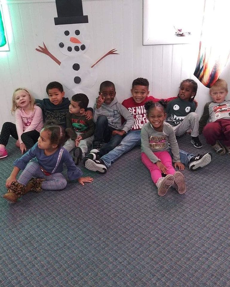Group of children sitting on the floor in a classroom