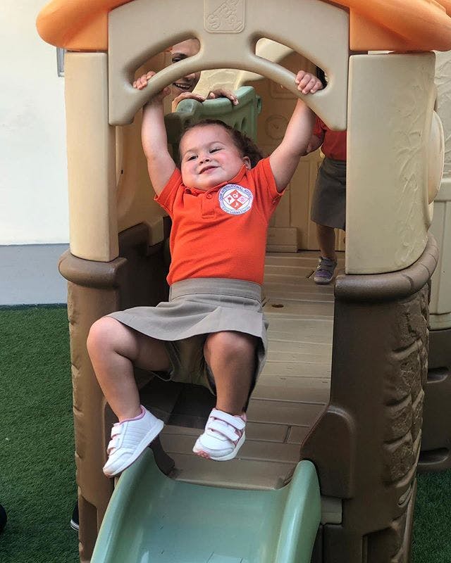 Child holding onto a bar on a playground structure