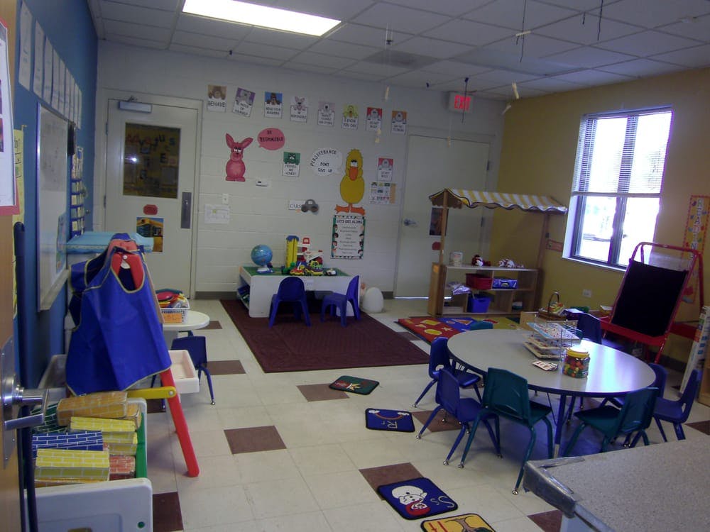 Classroom with small tables and chairs, toys, and decorations on the walls