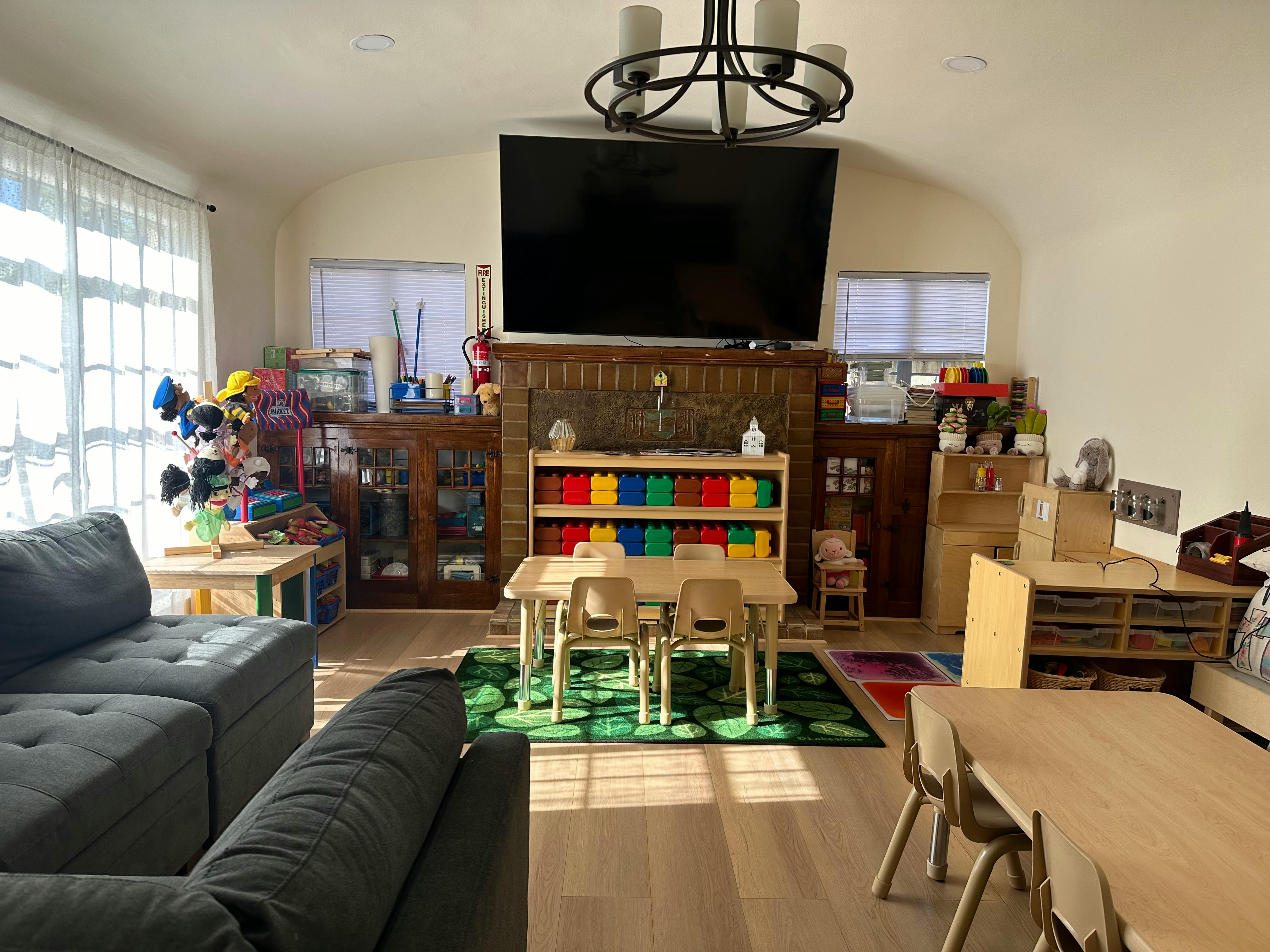 Living room with children's tables and chairs, and a large television