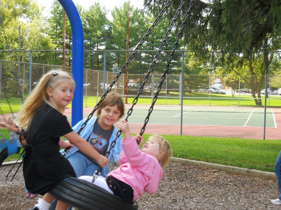 Three children on swings at a playground