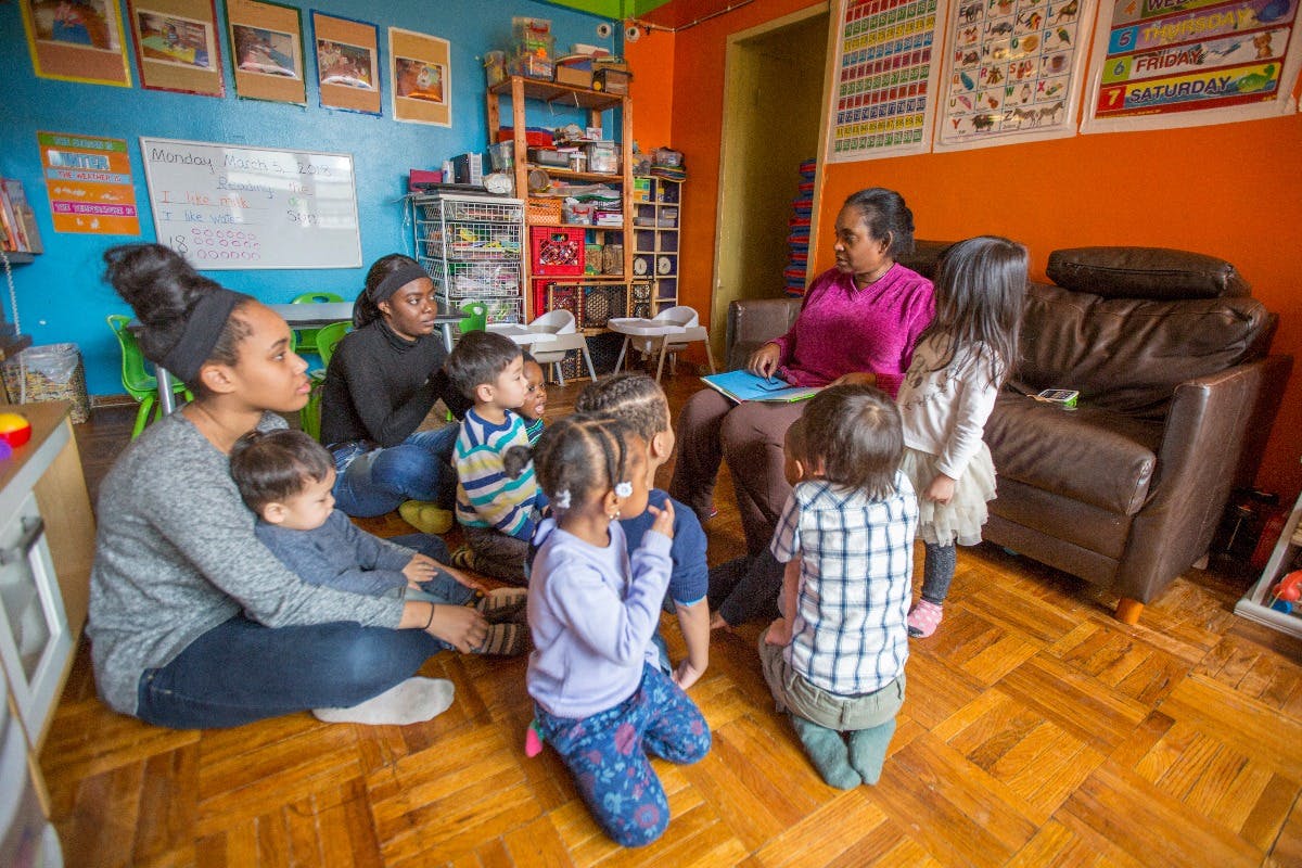 Adults and children sitting on the floor in a classroom