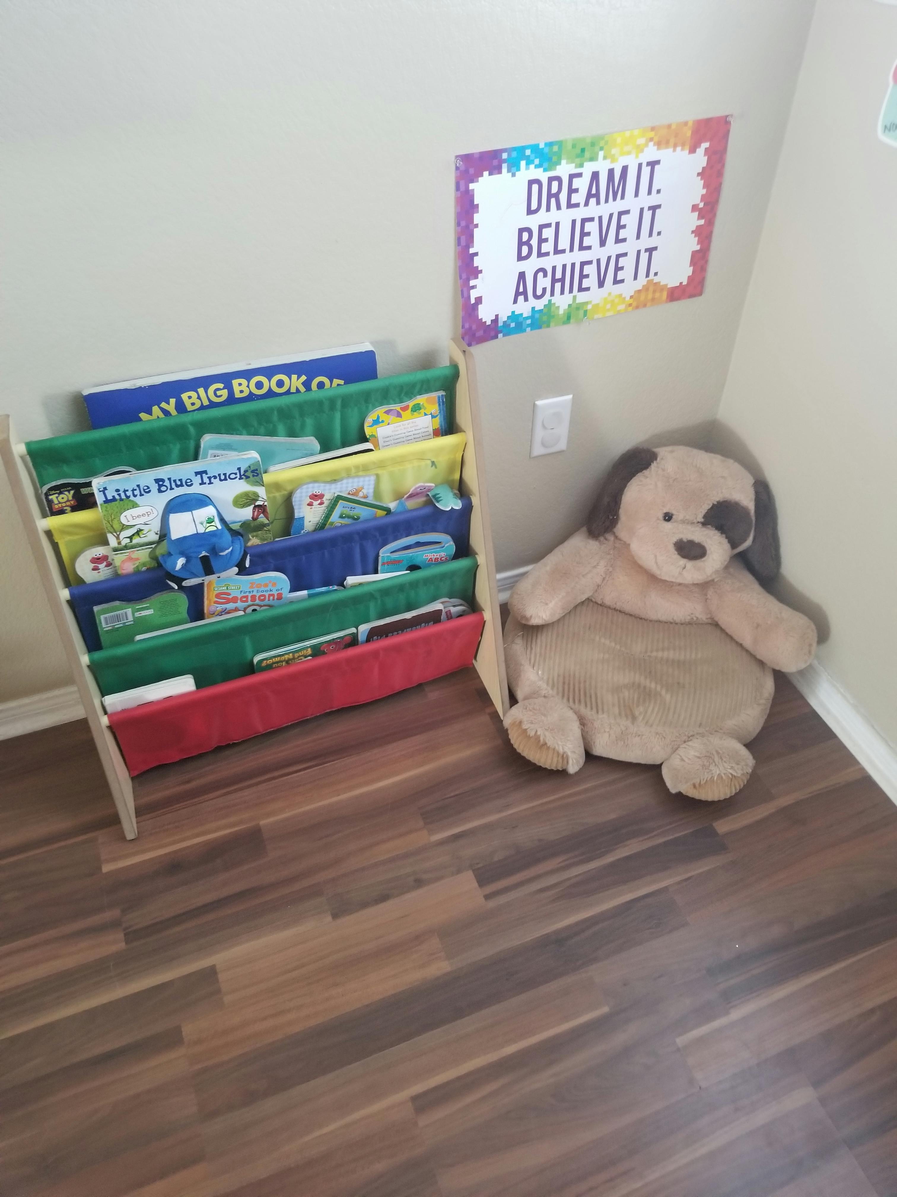 Bookshelf with children's books and a large stuffed dog toy