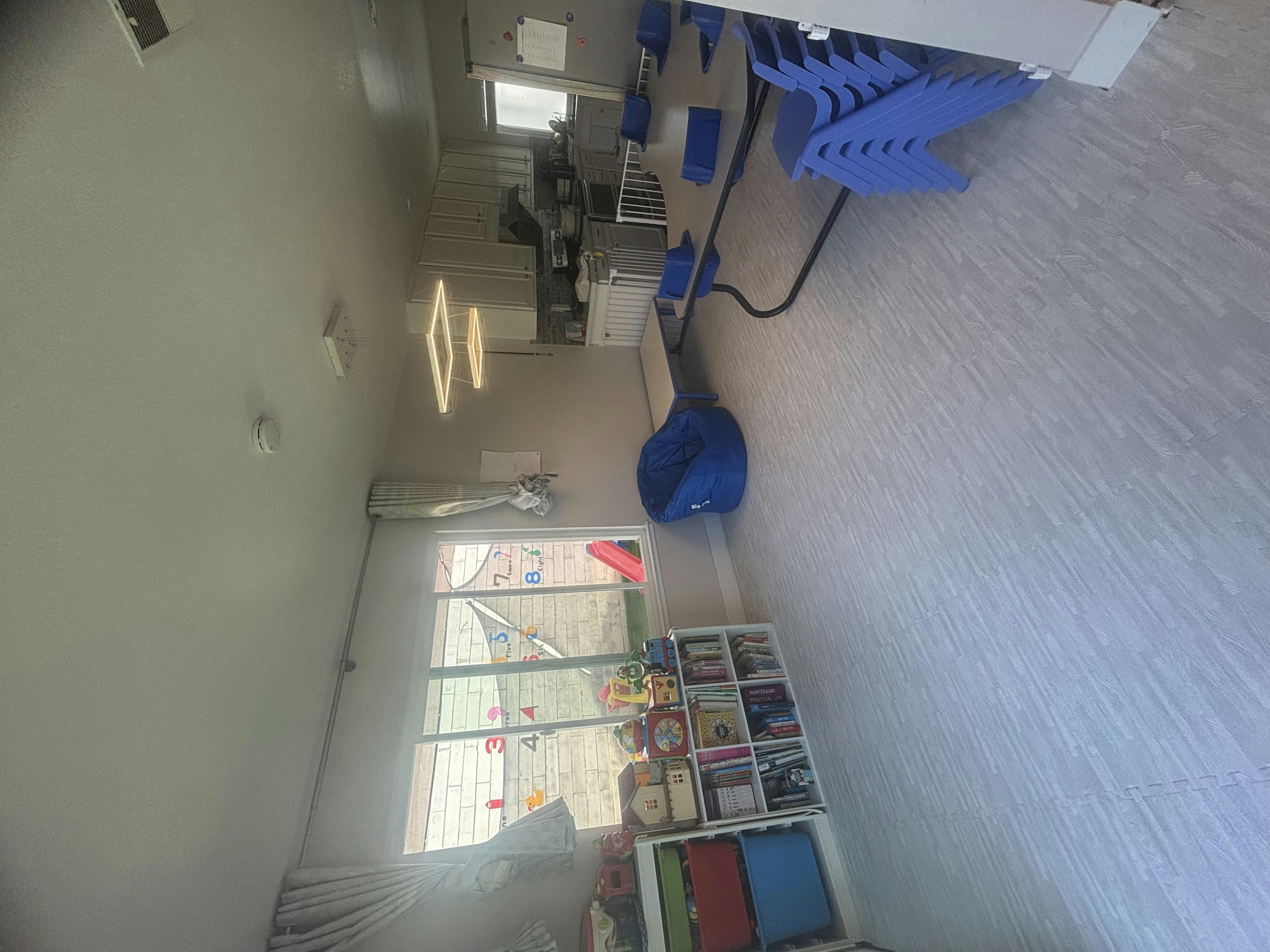 Room with a window, blue beanbag, and shelves with shelves of blue chairs