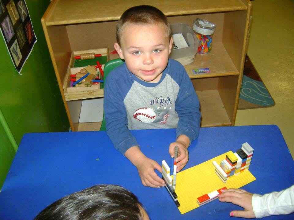 Child playing with building blocks at a table