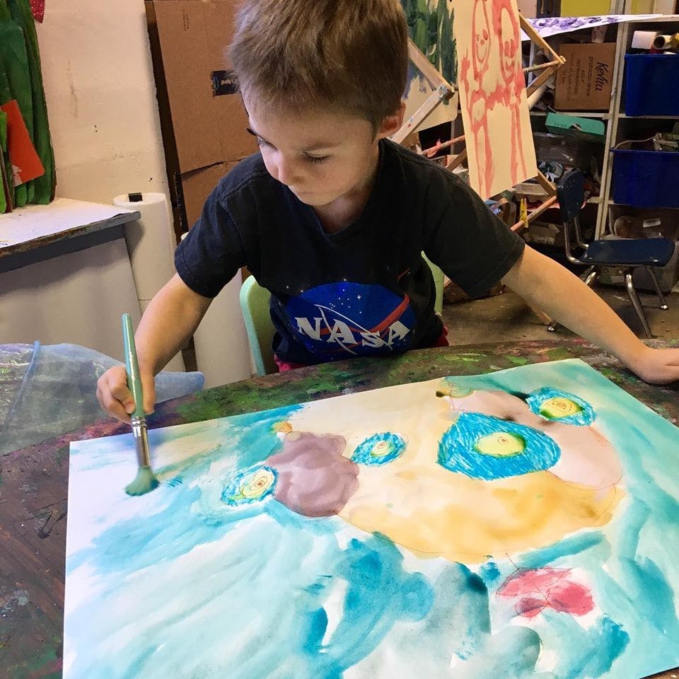 Child painting on a large sheet of paper
