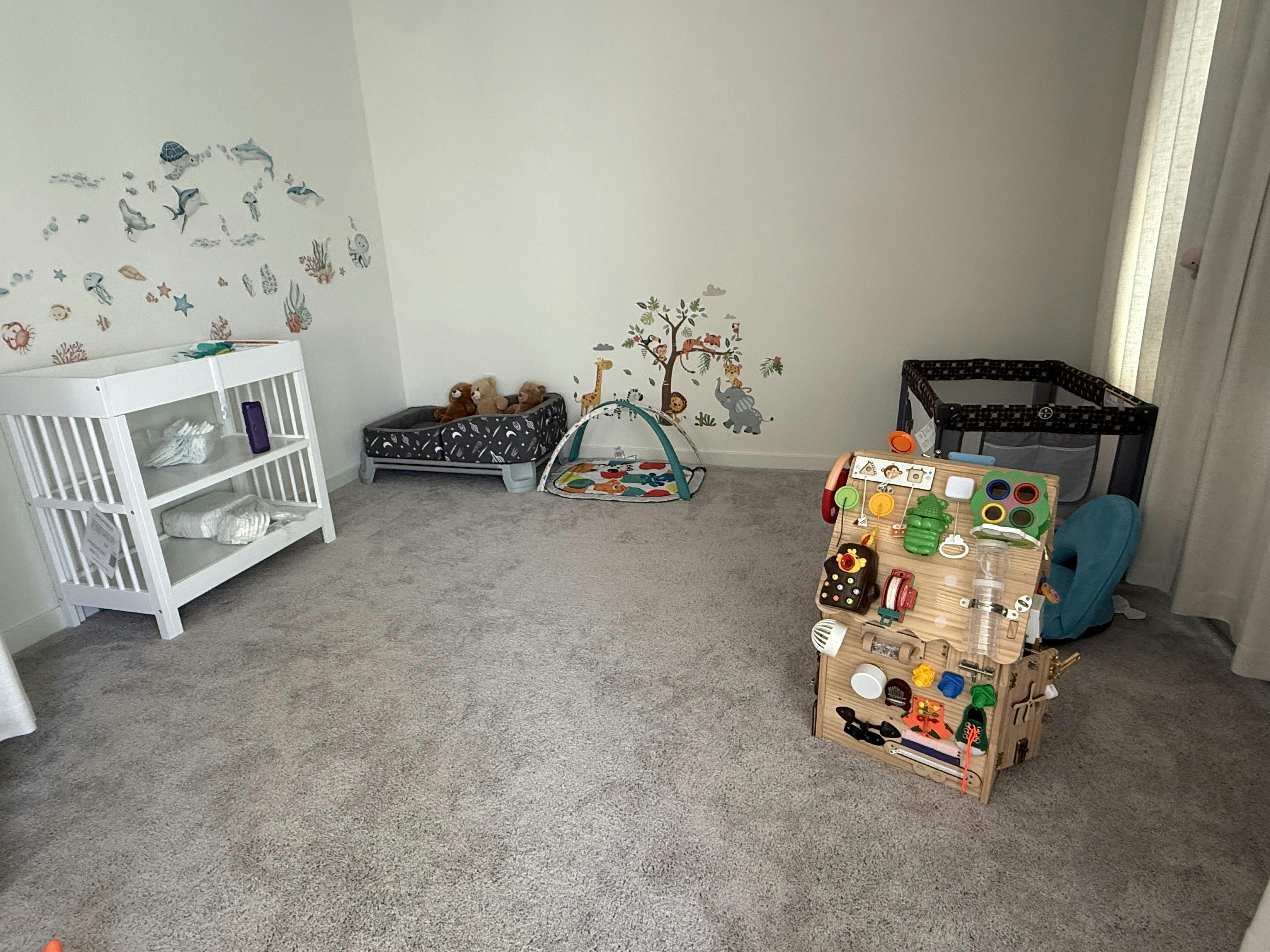 Nursery room with baby furniture toys and wall decals