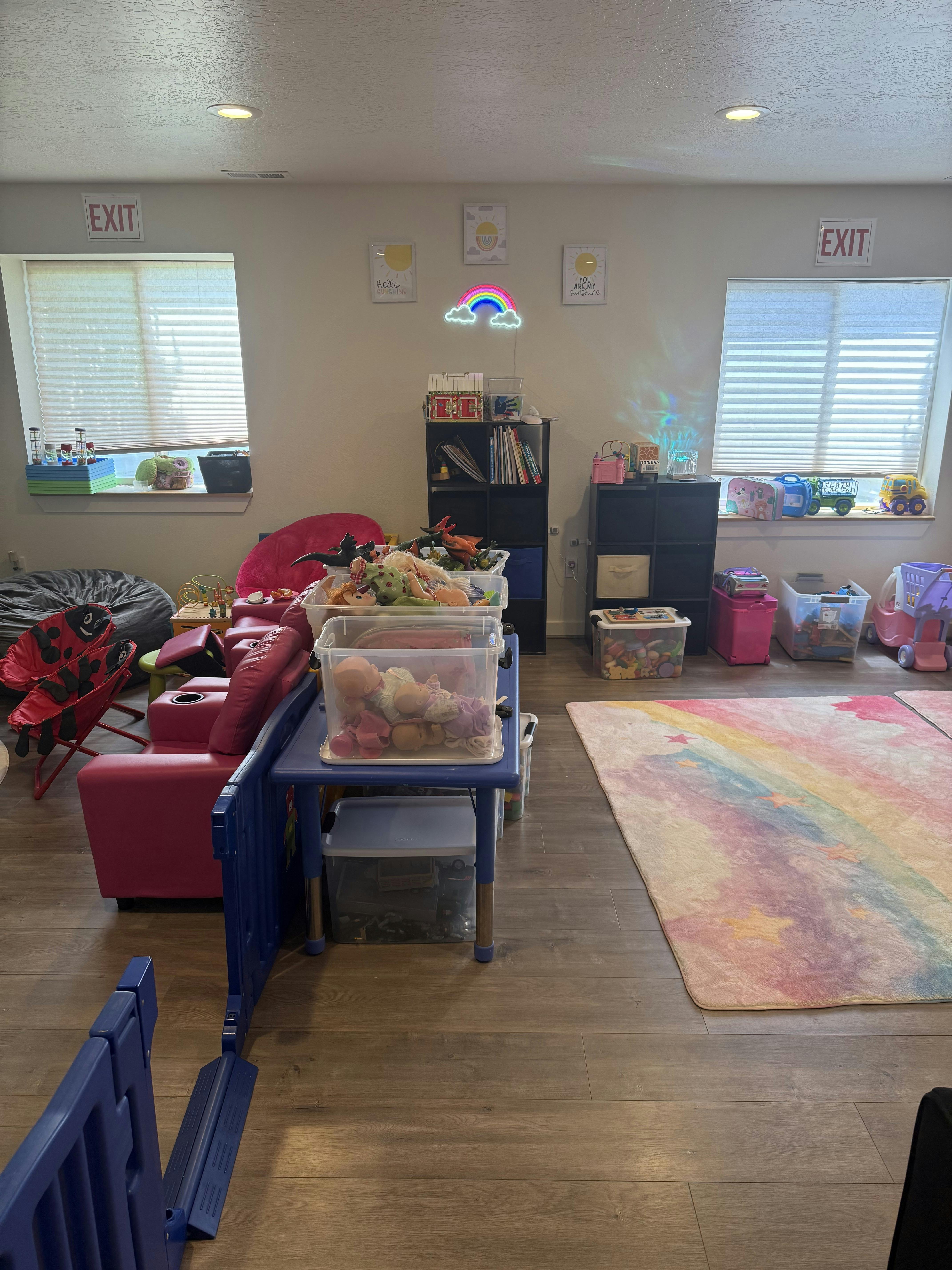 Playroom with children's furniture, toy bins, and a rainbow rug