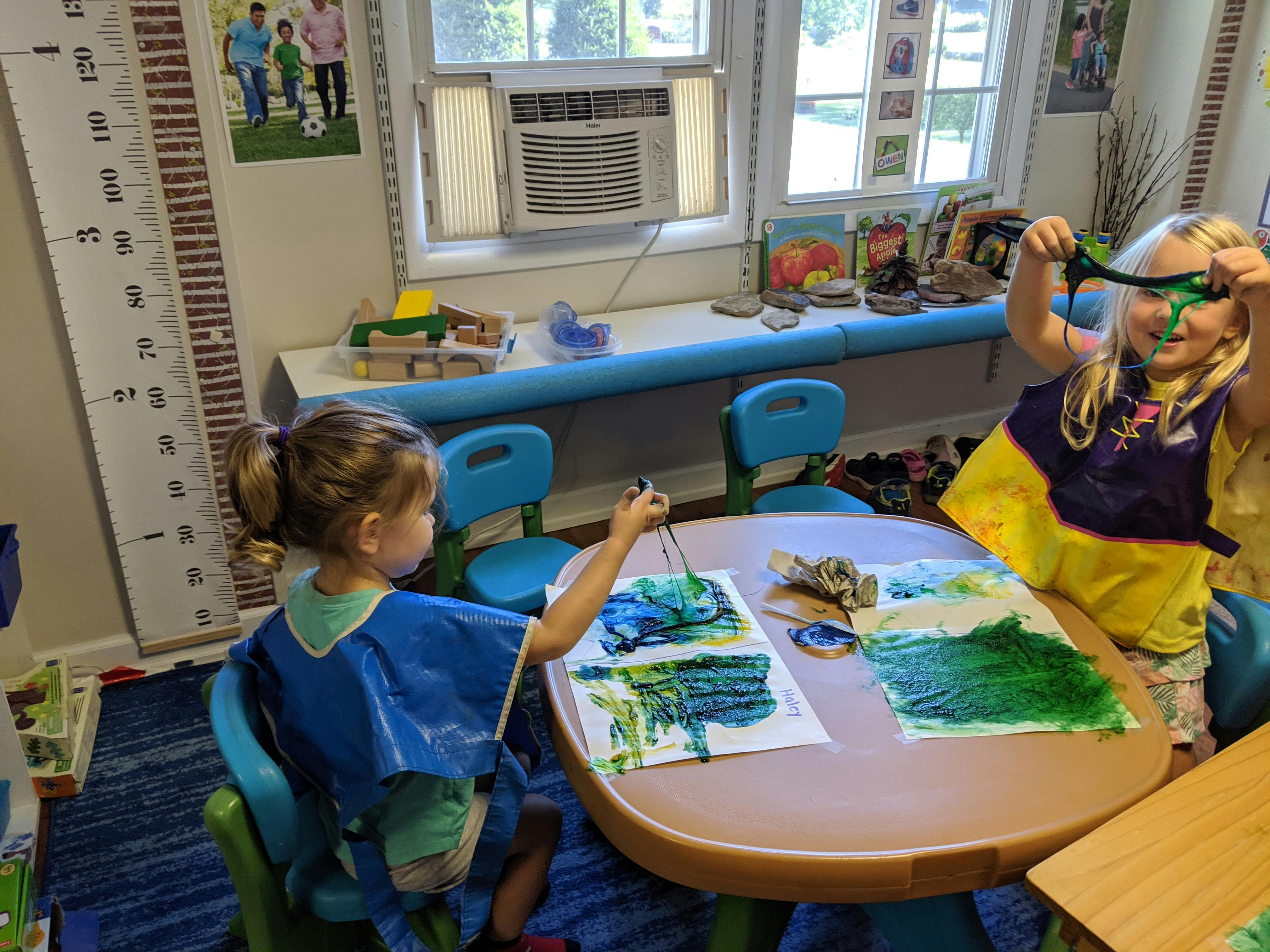 Two children painting at a table