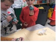 Two children holding up decorated ornaments
