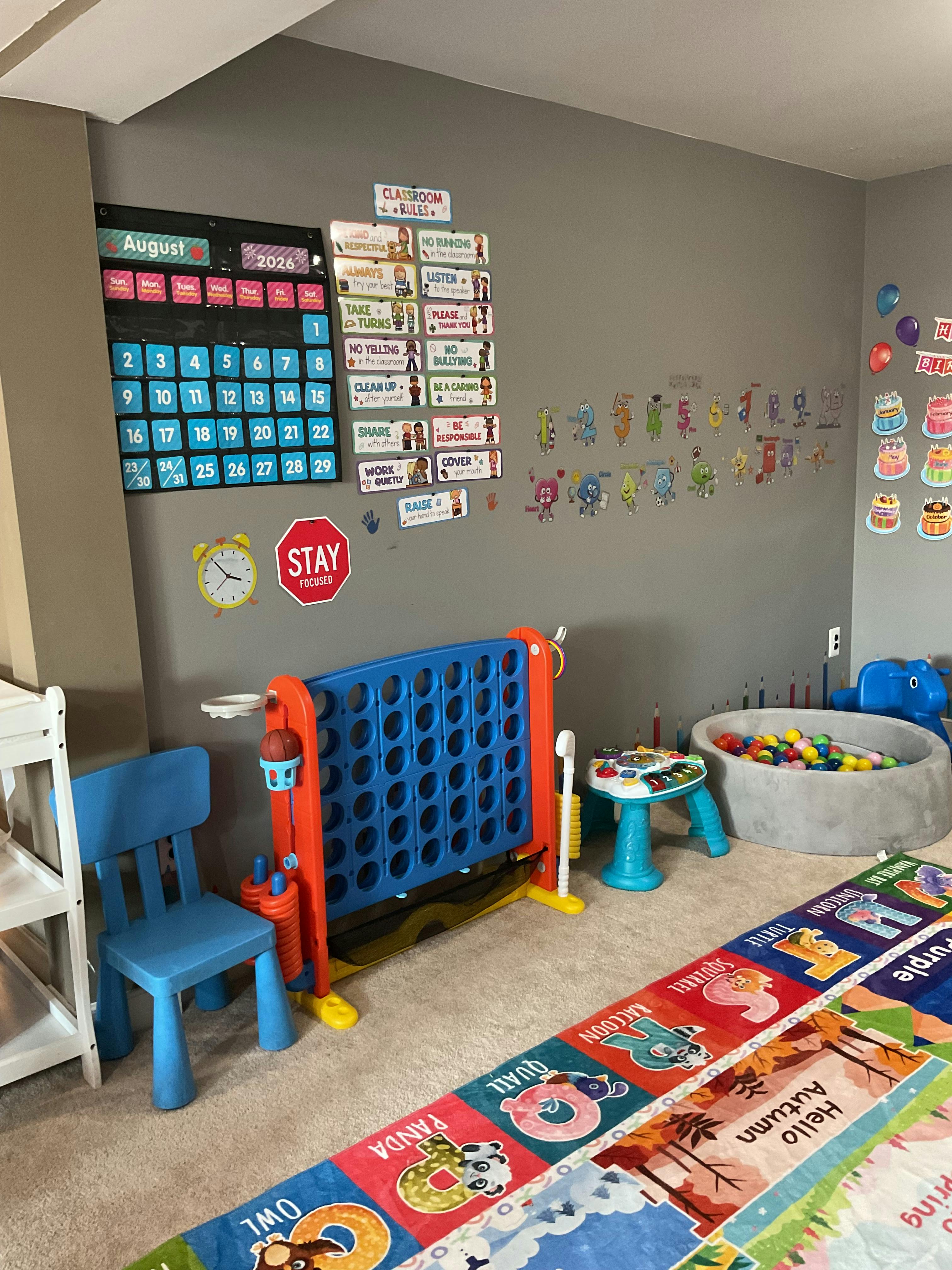 A playroom setup with educational posters, a toy ball pit, and games