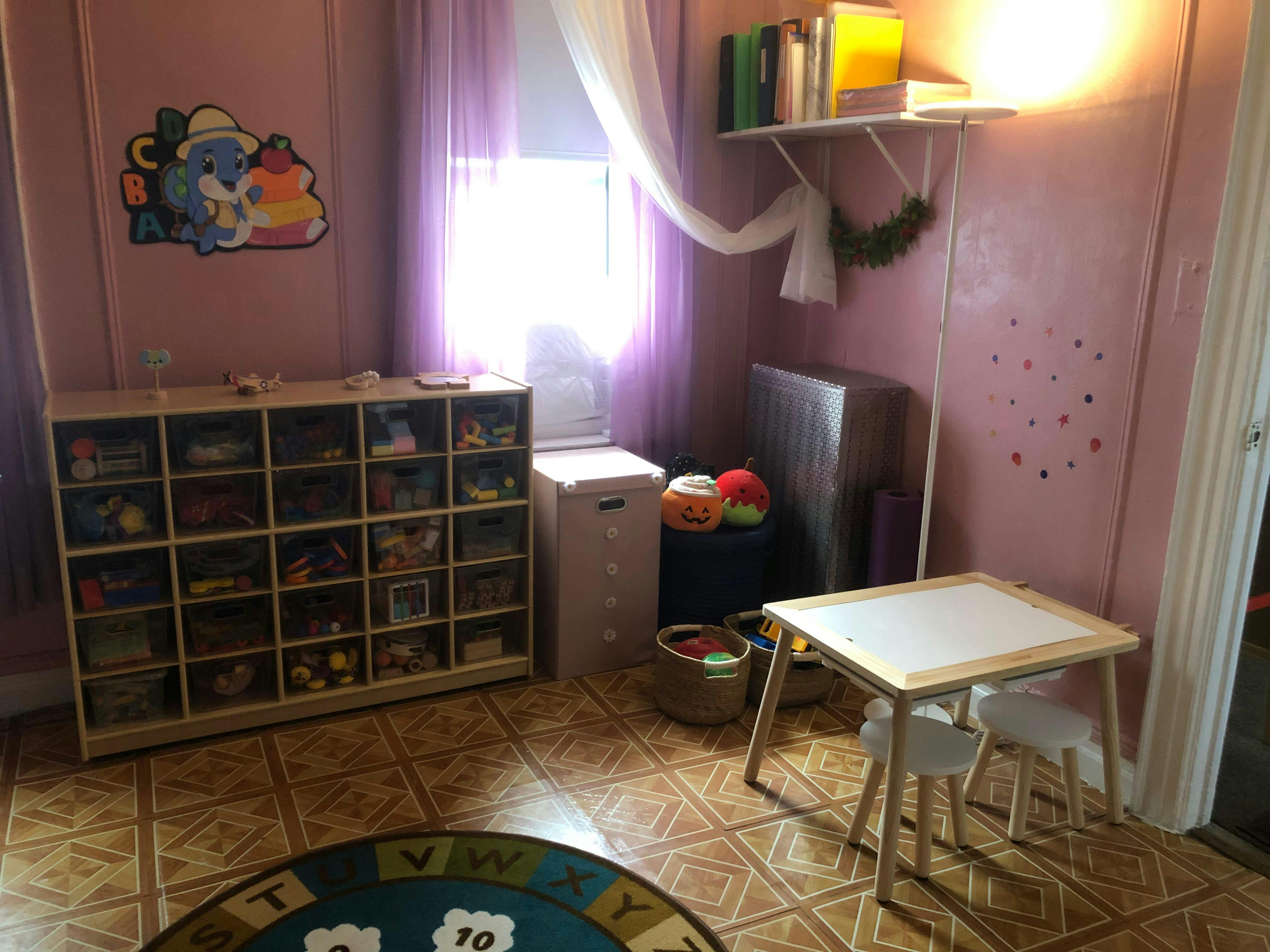 Playroom with toy storage, small table and chairs, and a round rug