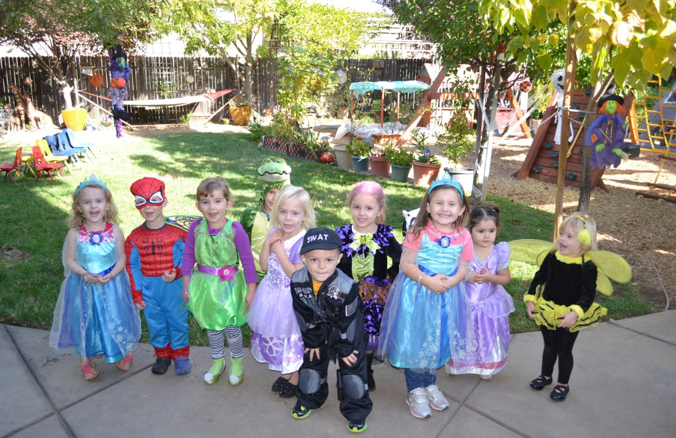 Group of children in various costumes standing outdoors