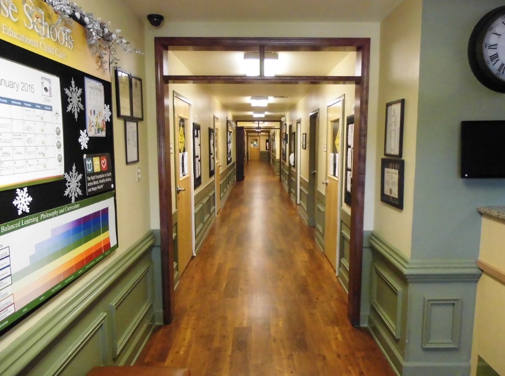 Long hallway with wooden floors and doors lining both sides