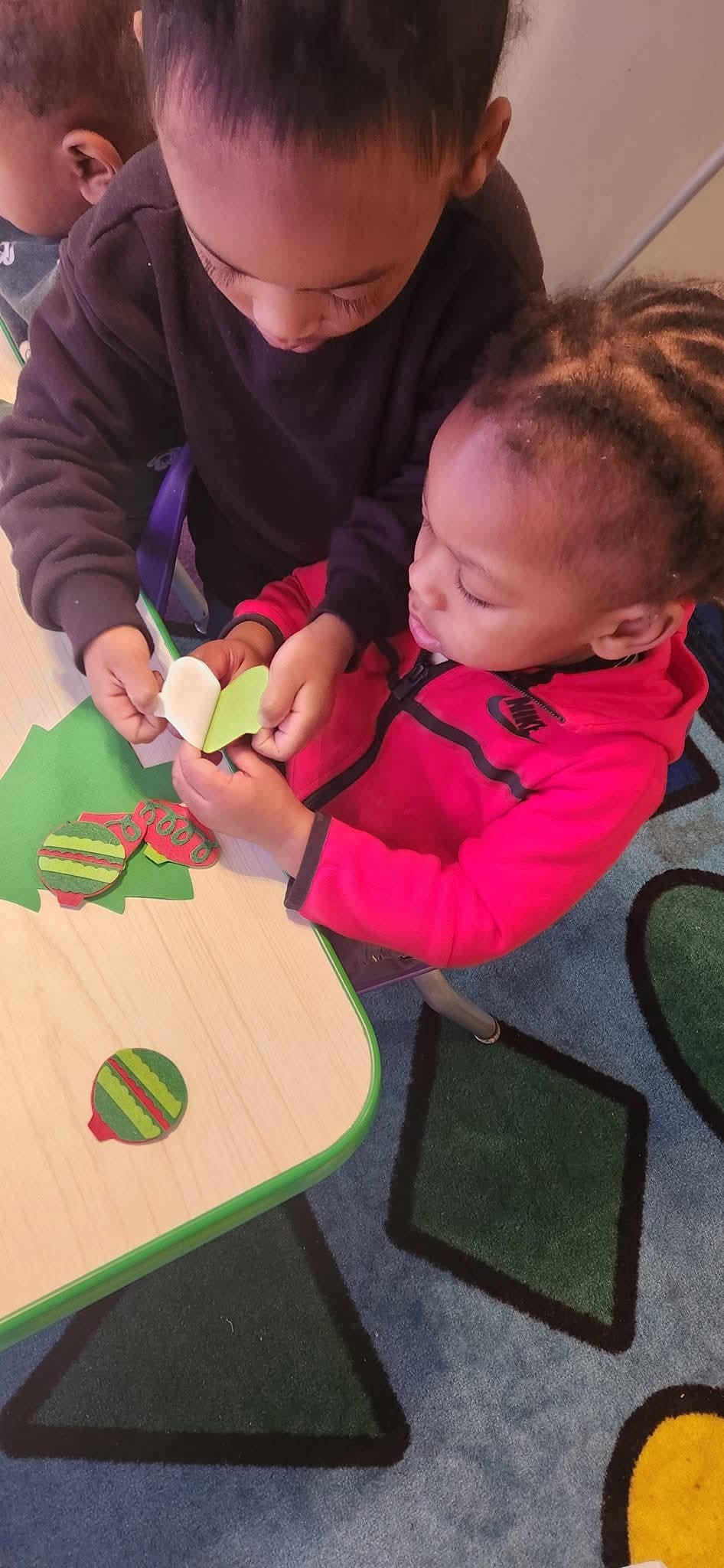 Two children working together on a craft project at a table