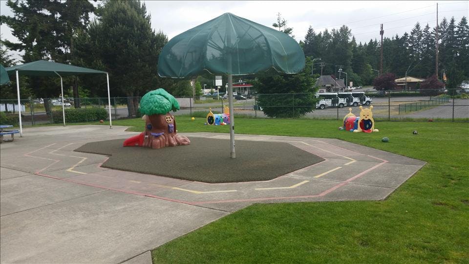 Playground with umbrella, treehouse slide, and colorful outdoor toys
