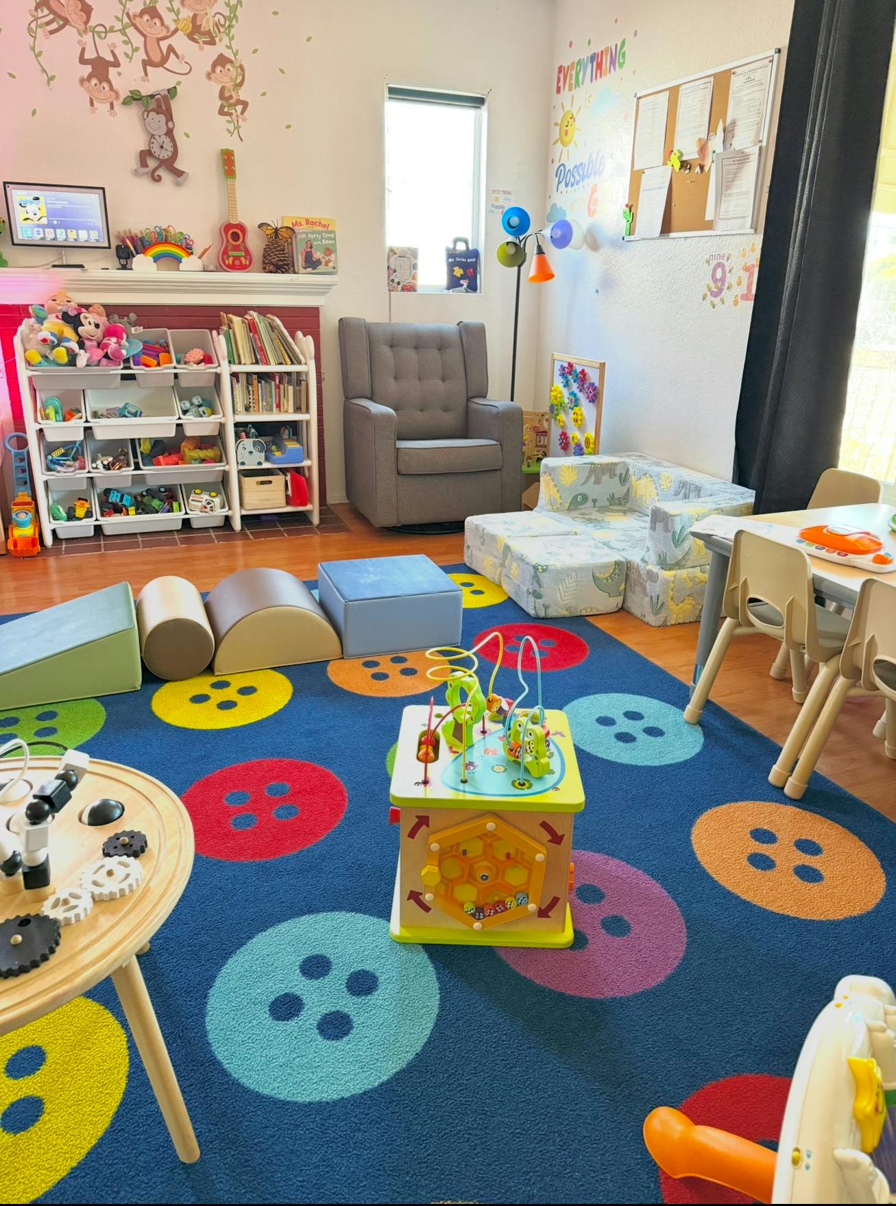 Playroom with colorful rug, toys, and child-sized furniture