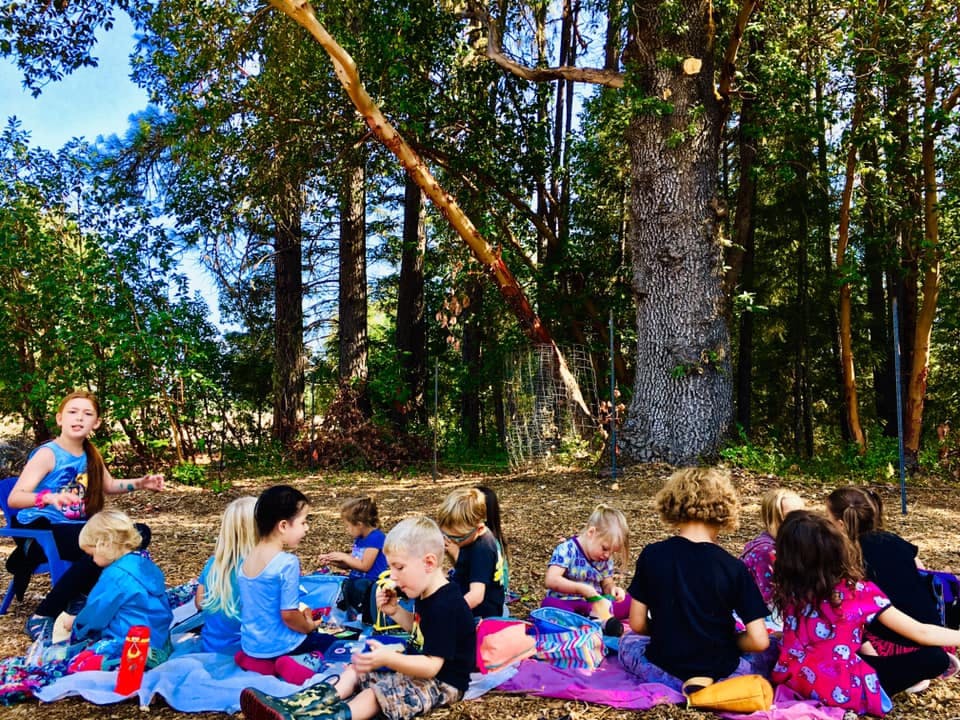 Group of children sitting on blankets outdoors