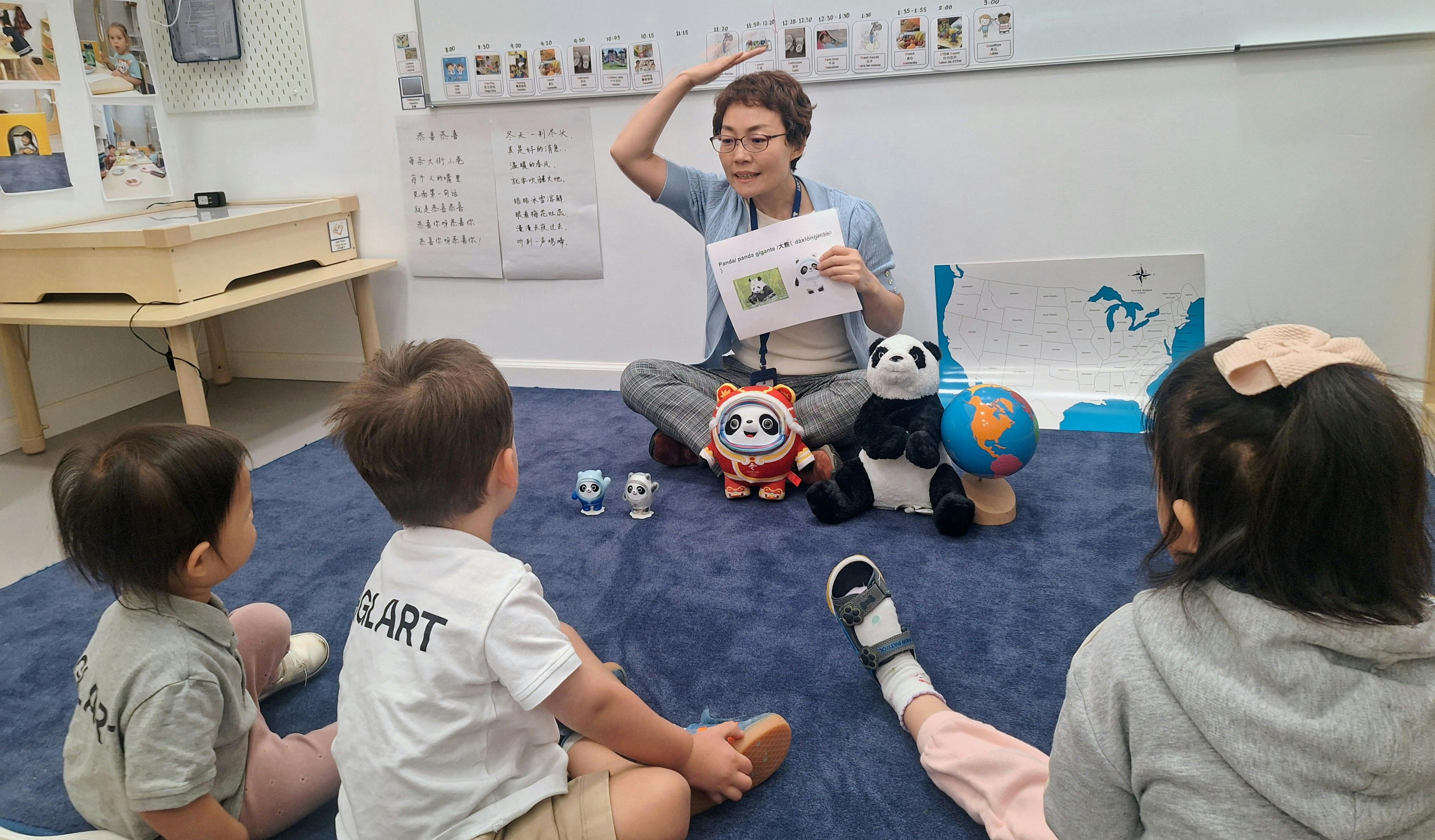 Person sitting on floor with children, holding a paper and gesturing
