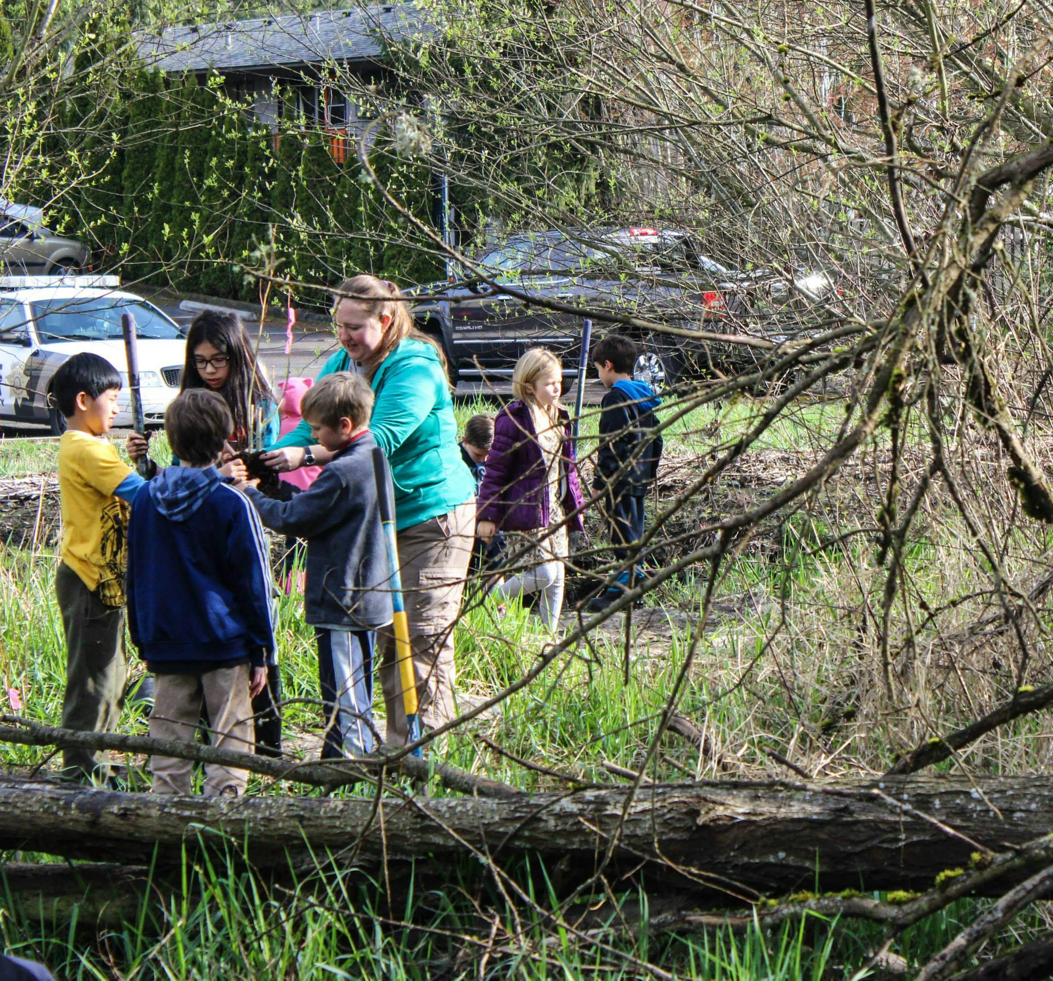 Adult and children planting in a grassy area