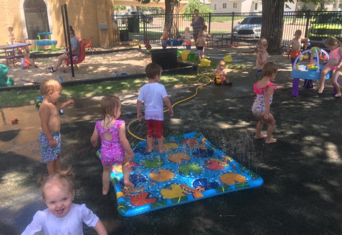 Children playing with water on a splash pad outdoors