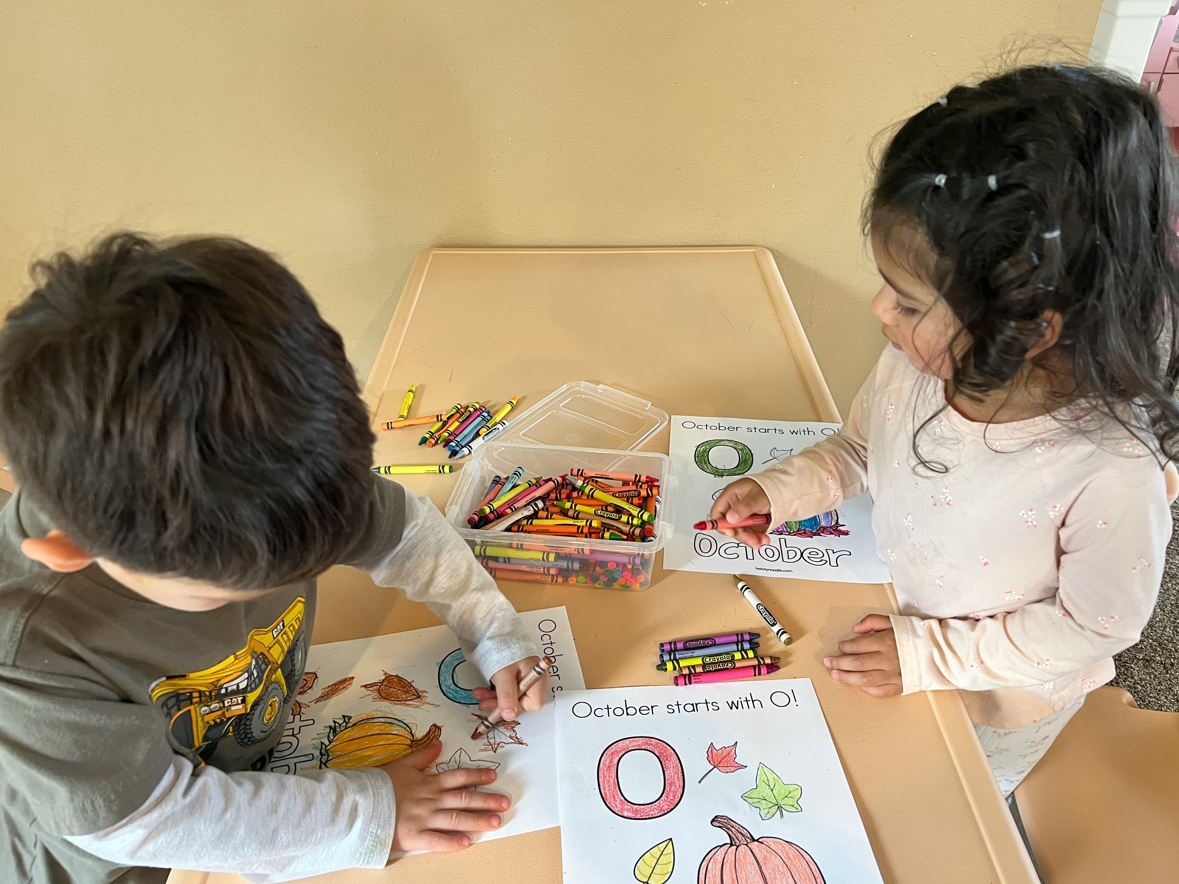 Two children coloring at a table