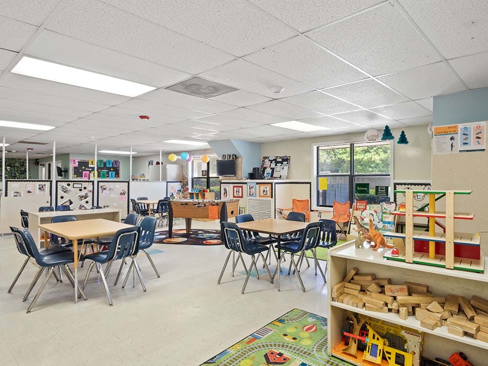 Children's classroom with tables, chairs, and play areas