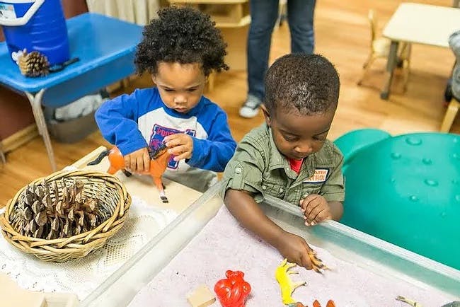 Two children playing with toys at a table