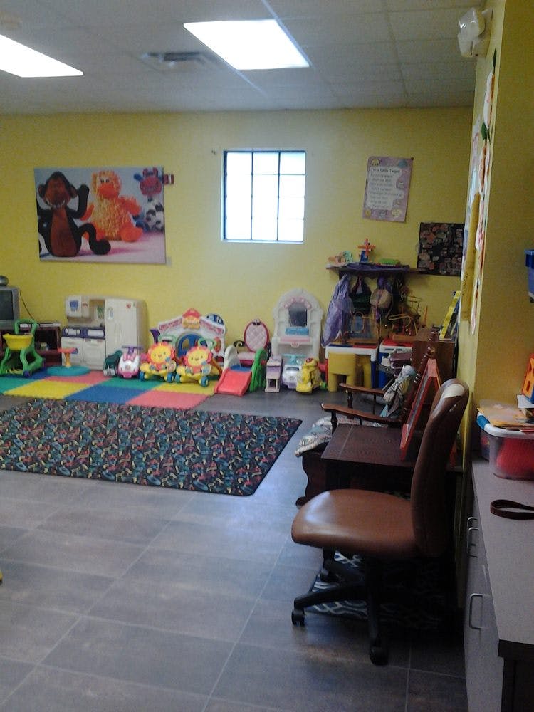 Playroom with colorful mats, toys, and small chairs
