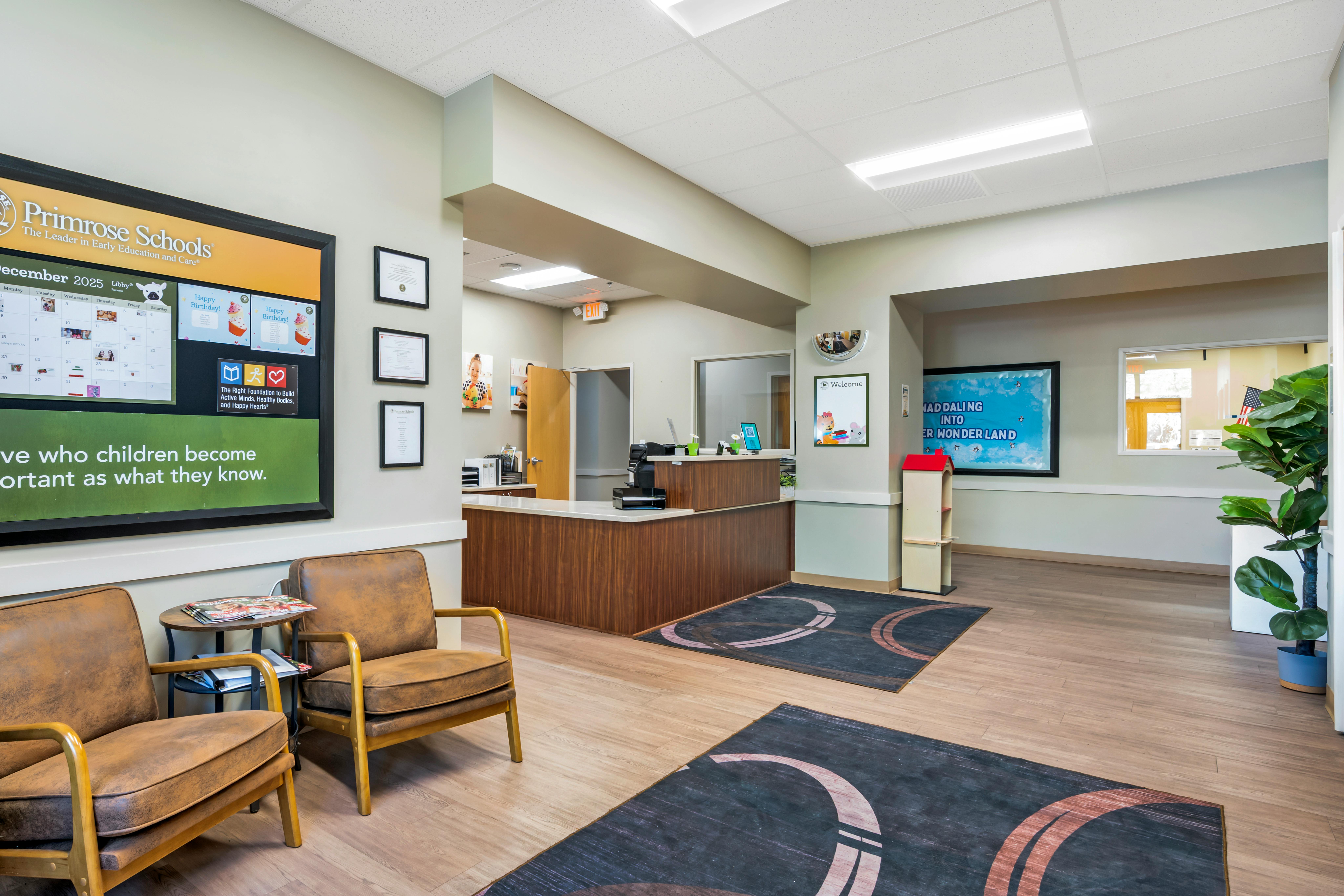 Reception area of a school with a front desk, seating, and notice boards