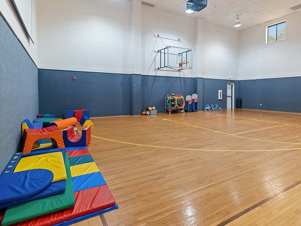 Indoor basketball court with soft play equipment and small hoops