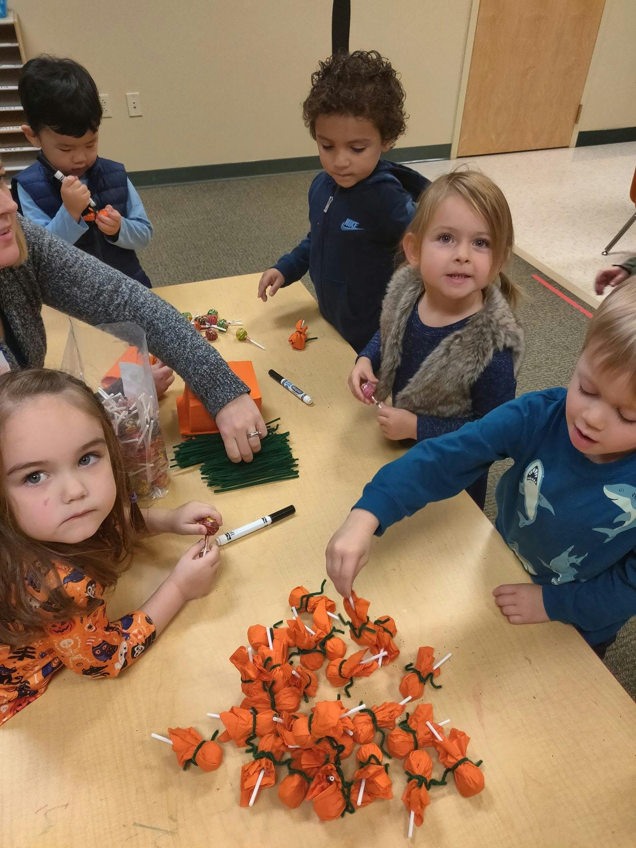 Children and an adult making crafts at a table