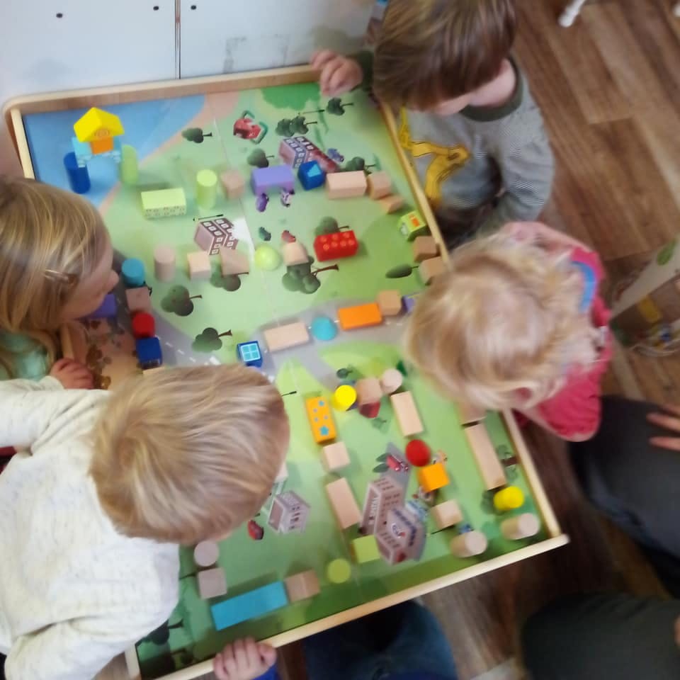 Children playing with a wooden block activity table