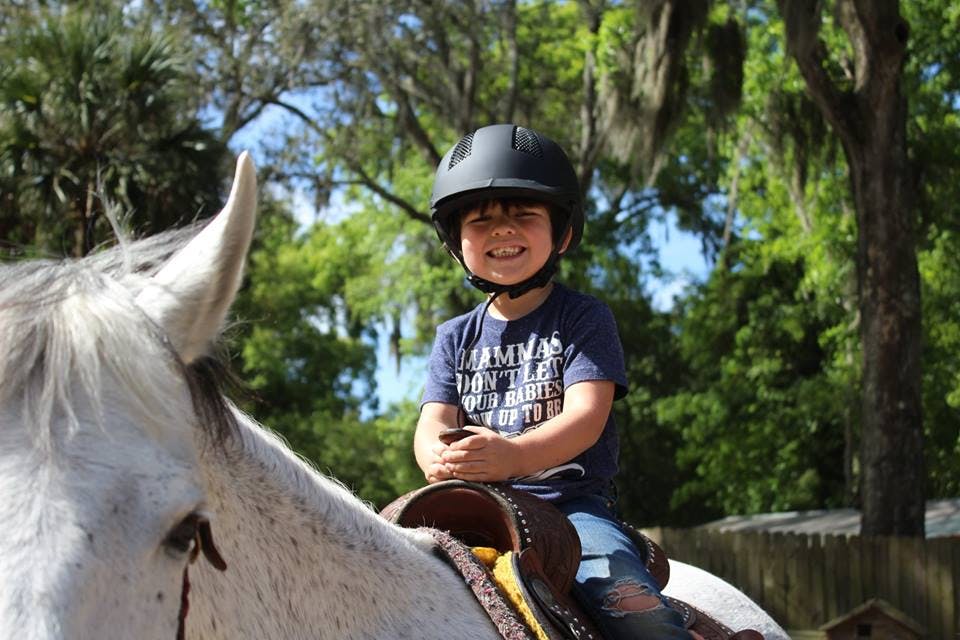 Child in a helmet riding a horse