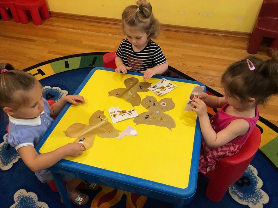 Three children at a table doing crafts
