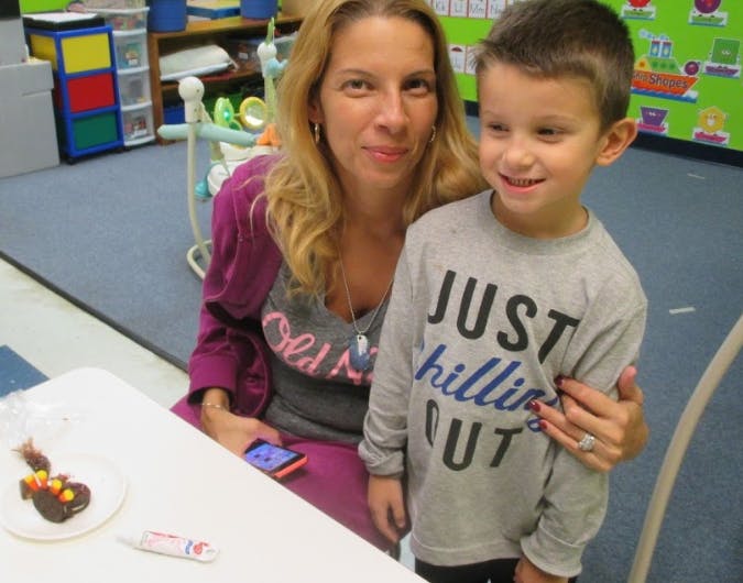 Person and child standing together in a classroom