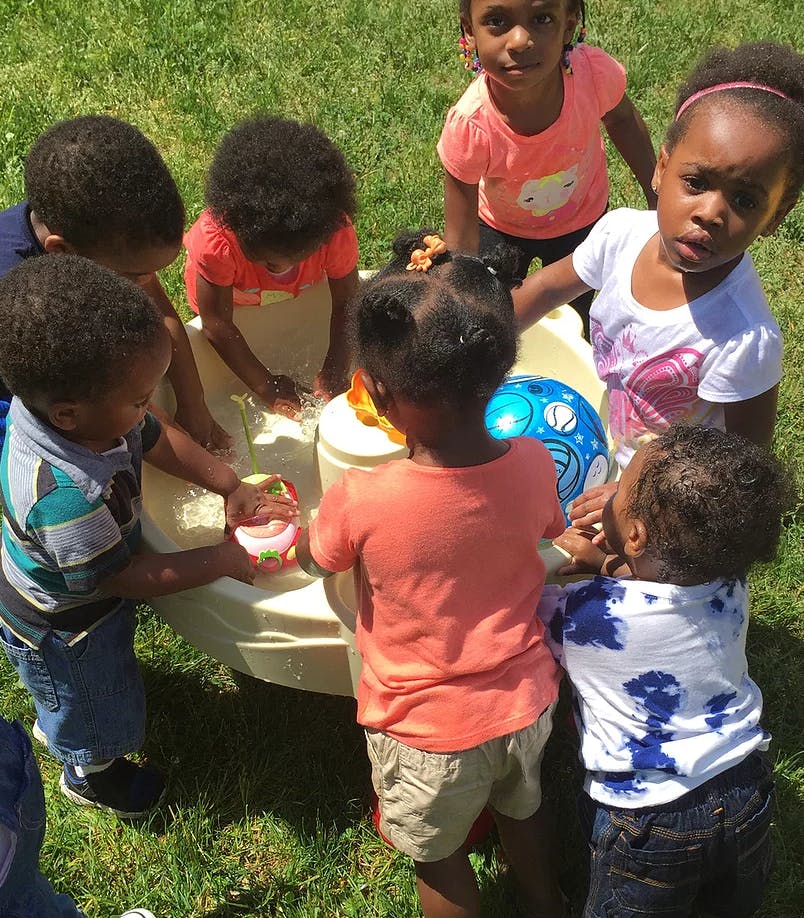 Children playing with a water table outdoors