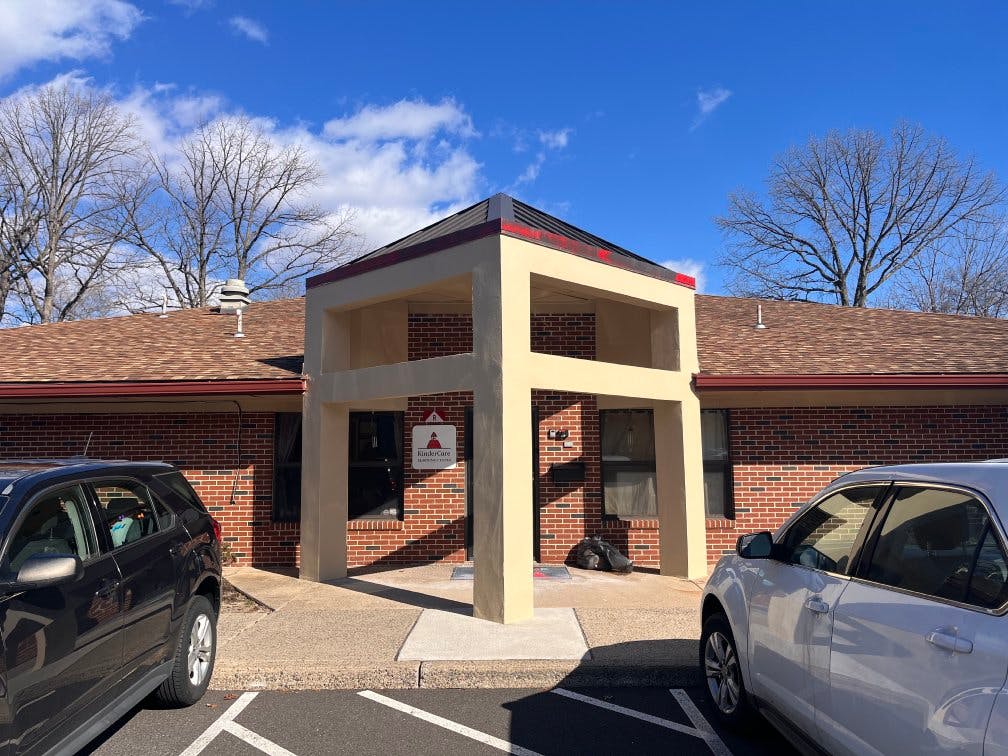 Brick building entrance with a beige archway and "KinderCare" sign