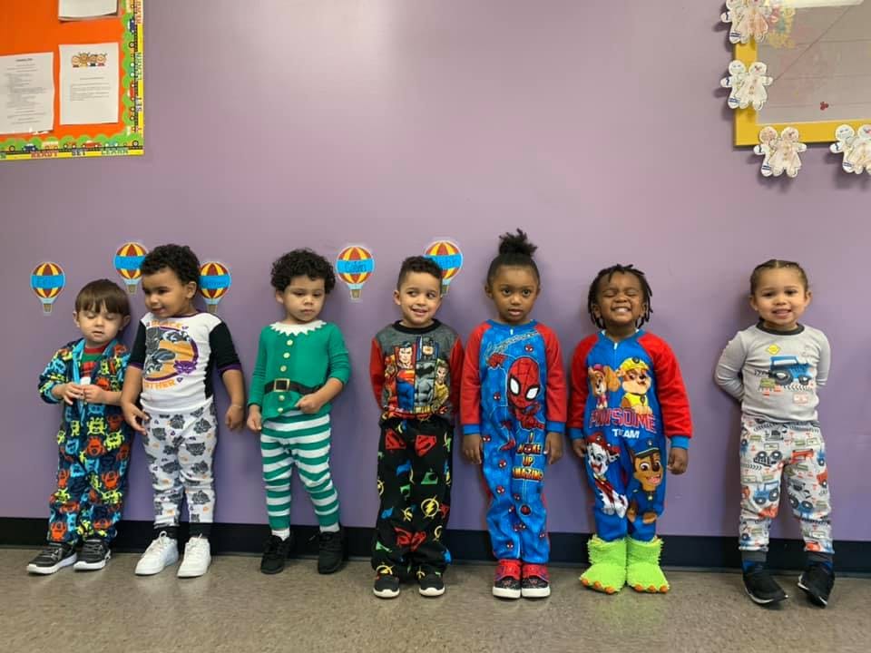 Six children in pajamas standing in a line