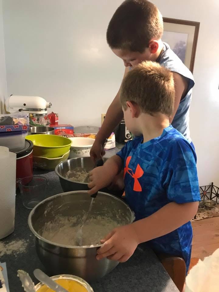 Two children mixing ingredients in bowls in a kitchen