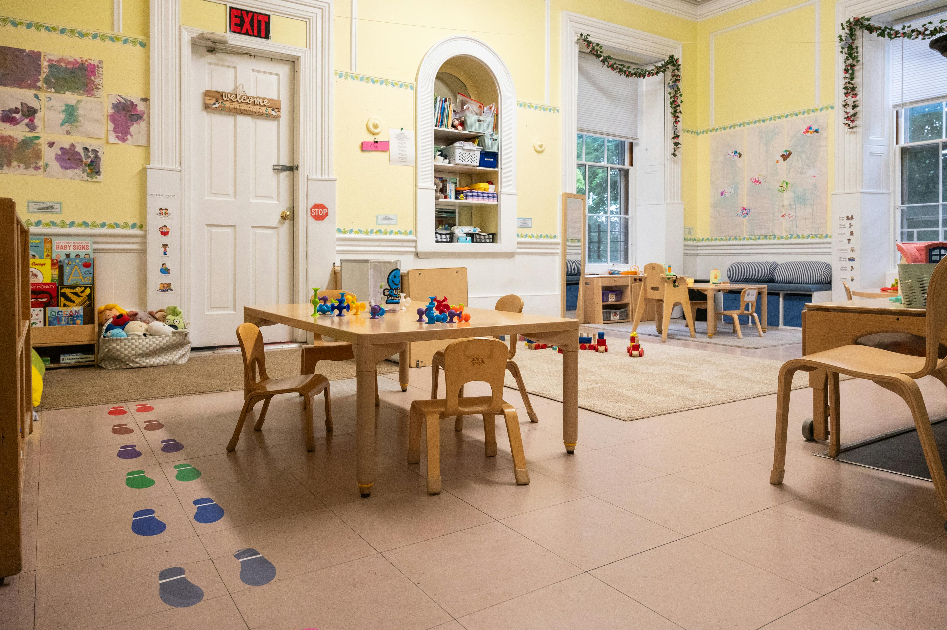 Classroom interior with small wooden tables and chairs for children
