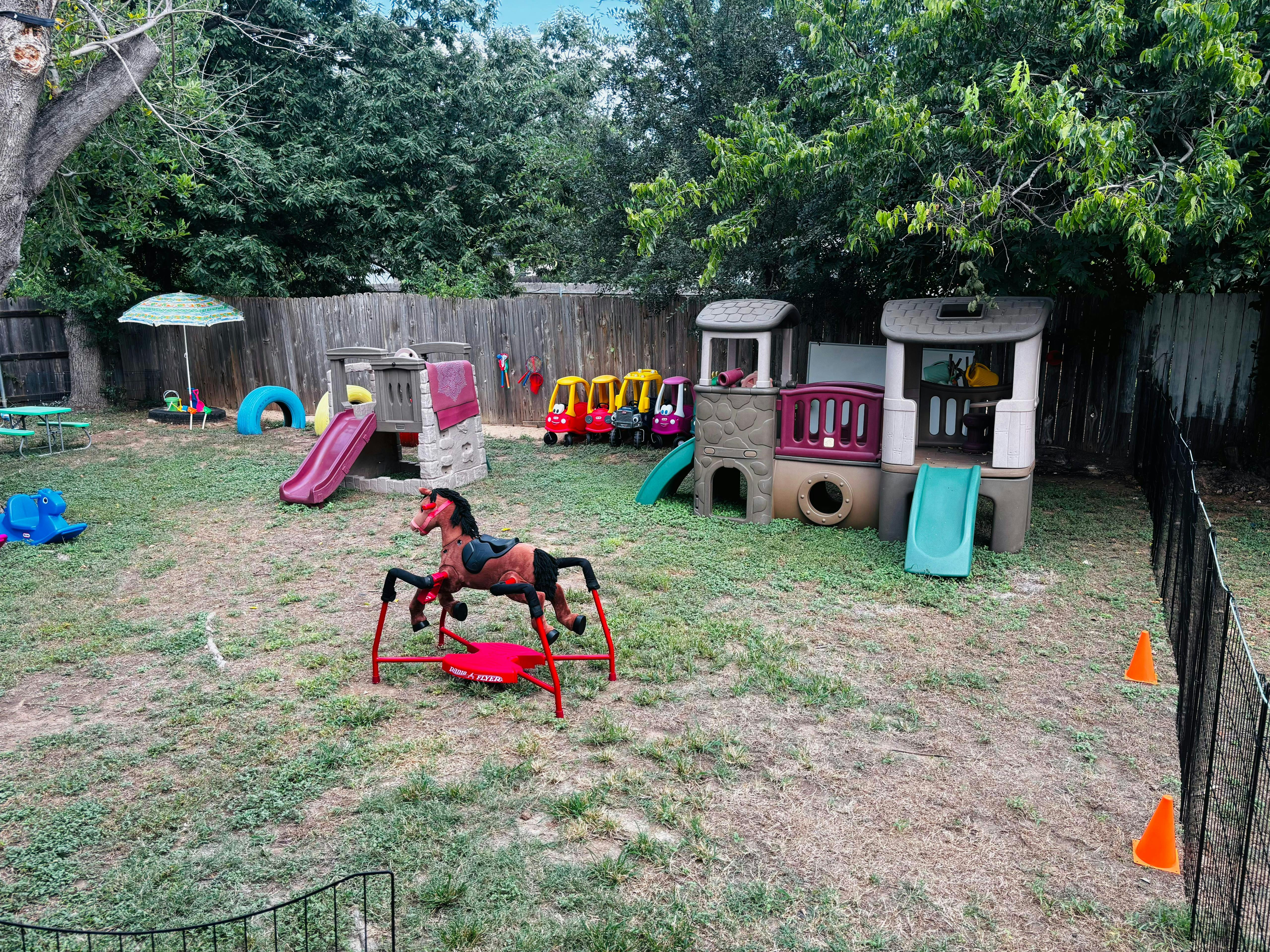 Outdoor playground with slides, playhouses, and a spring horse