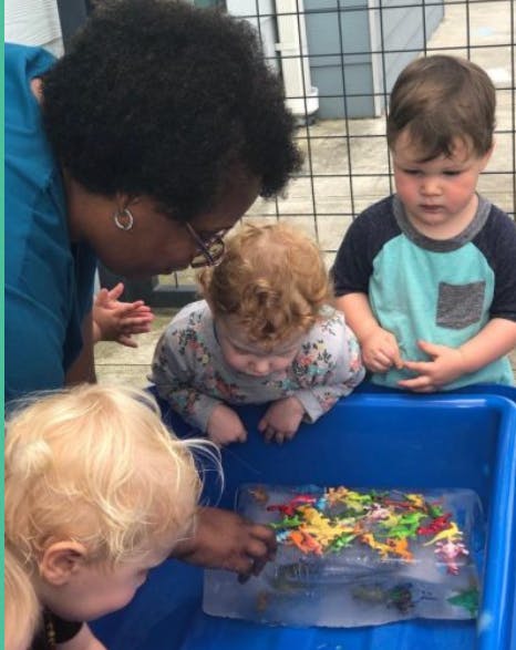 Person and three children looking at toys frozen in ice