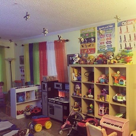 Playroom with shelves of toys, play kitchen, and colorful curtains