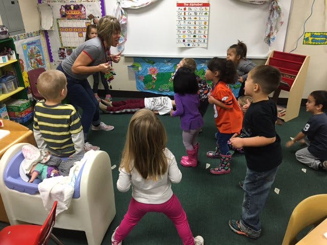 Adult interacting with children in a classroom