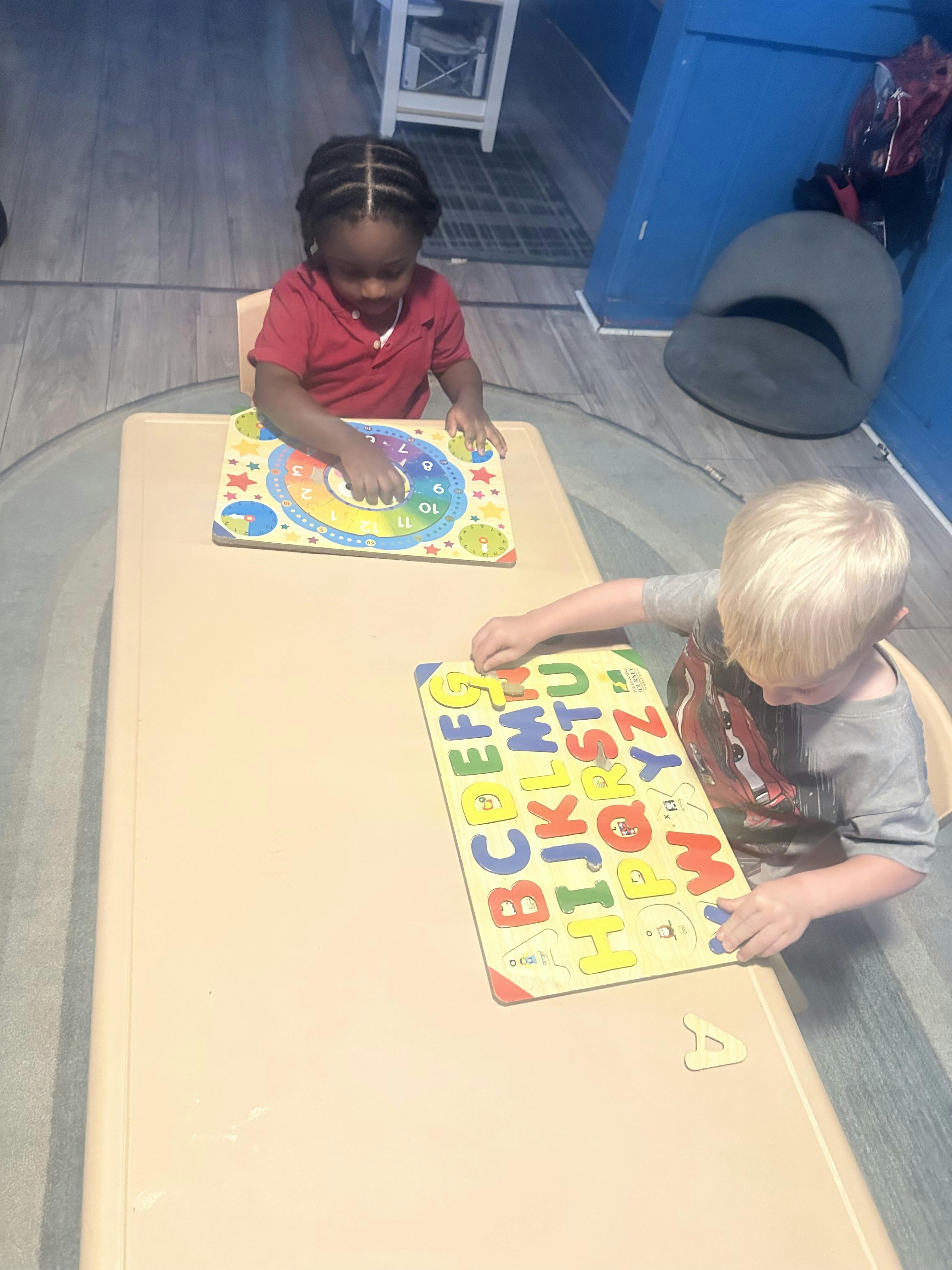 Two children playing with educational puzzles at a table